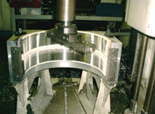 A bearing shell being finish machined after flame sprayed Babbitt.