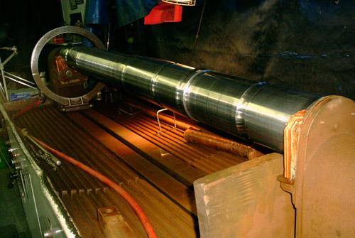 A shaft clamped in the magnetic particle inspection unit's head.