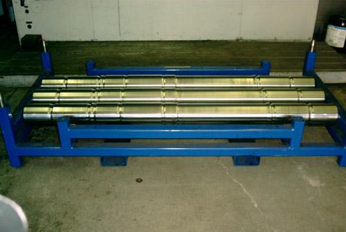 Polished shafts racked and ready for magnetic particle inspection.