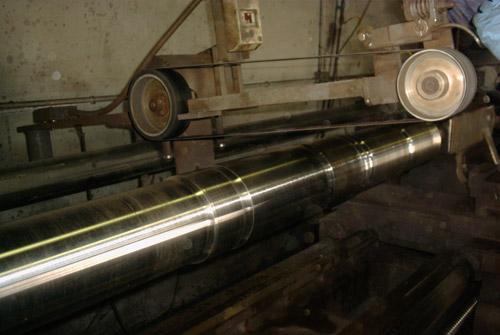 A shaft being polished in preparation for magnetic particle inspection.