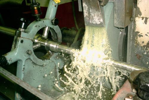A shaft fit being finish ground under flooding coolant.