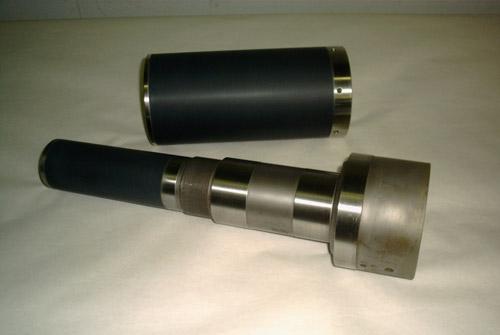 A ceramic packing sleeve beside a progressive cavity pump drive shaft, both ceramic coated.